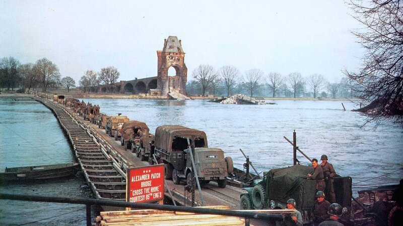 Die Doku zeigt beeindruckende Farbaufnahmen der legendären Brücke von Remagen sowie die Gesichter der Besiegten und begleitet die US-Truppen auf ihrem Weg durch den Westerwald Richtung Thüringen. (Foto: Rheinüberquerung von US-Truppen im März 1945) – Bild: TVNOW /​ Spiegel TV