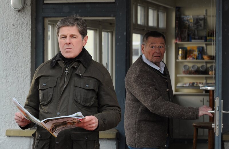 Da Alois ausversehen Bambergers bestellte Zeitschrift verkauft hat, will er ihm ein gebrauchtes Exemplar geben. Von links: Roland Bamberger (Horst Kummeth) und Alois Preissinger (Erich Hallhuber). – Bild: BR/​Marco Orlando Pichler