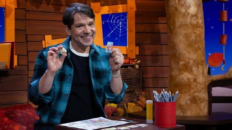 Es ist MACHMiT!-Woche im Baumhaus und Juri zeigt, was man mit den verschiedenen Spielkarten machen kann und deckt eine Quatschkarte auf. – Bild: KiKA