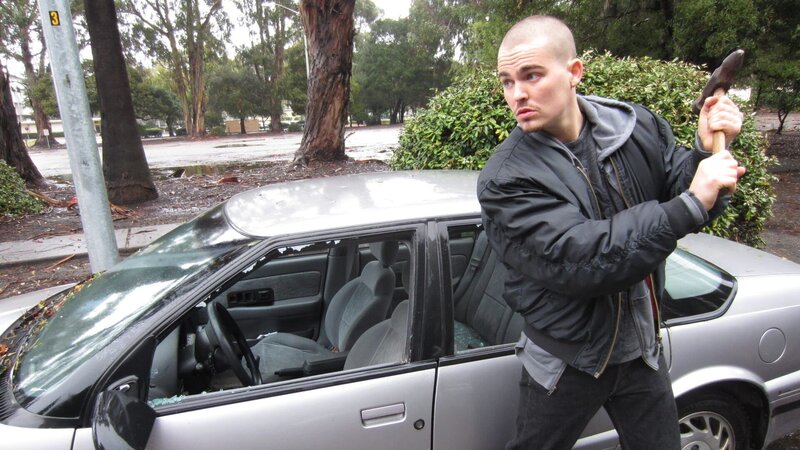 Mark Maher breaking a car window. – Bild: Discovery ID