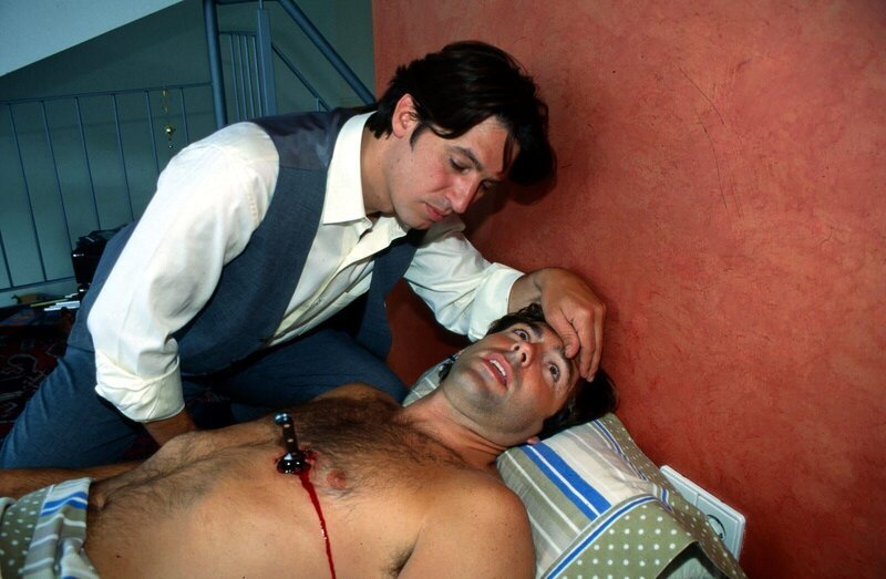 Kommissar Moser (Tobias Moretti, l.) untersucht die Leiche. Es handelt sich um Karin Friedls Freund, der im Schlaf erstochen wurde … – Bild: SAT.1 /​ Ali Schafler