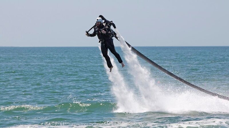 Eric Young wearing a jet pack. – Bild: Warner Bros. Discovery