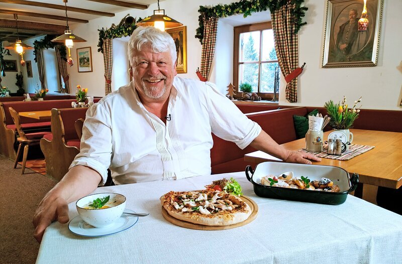 Alpengasthof Hindenburghütte auf der „Hemmersuppenalm“ in Reit im Winkl: Wirt Günter Dirnhofer stellt das Menü des Tages vor. Vorspeise: Sauerrahmsuppe – Hauptgericht: Rahmfleckerl -Nachspeisen-Tris. – Bild: BR/​Bewegte Zeiten Filmproduktion GmbH/​Astrid Güldner