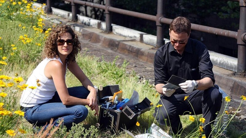 Die Detectives Stella Bonasera (Melina Kanakaredes) und Mac Taylor (Gary Sinise) müssen sich mit Tatortfotos begnügen, um die Ereignisse während Macs Bewusstlosigkeit zu rekonstruieren. – Bild: Foto: TVNOW /​ CBS