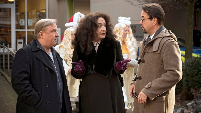 Auf zum Weihnachtsmarkt: Staatsanwältin Wilhelmine Klemm (Mechthild Großmann, Mitte) überredet Kommissar Frank Thiel (Axel Prahl, links) und Prof. Karl-Friedrich Boerne (Jan Josef Liefers, rechts) noch zu einem Glas Glühwein. – Bild: WDR/​Martin Valentin Menke