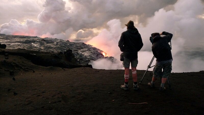 Director Mike Ibeji and Director of Photography Mike Single filming live lava flows in Hilo Hawaii as the sun rises and the lava hits the ocean. (Photo credit: © NHNZ Ltd/​ Tim Brott) – Bild: Copyright © The National Geographic Channel.