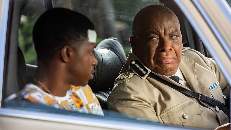 Während der Fahrt vom Krankenhaus nach Hause überrascht Marlon Pryce (Tahj Miles, l.) Commissioner Selwyn Patterson (Don Warrington, r.) mit einer unerwarteten Ankündigung. – Bild: ZDF und Denis Guyenon