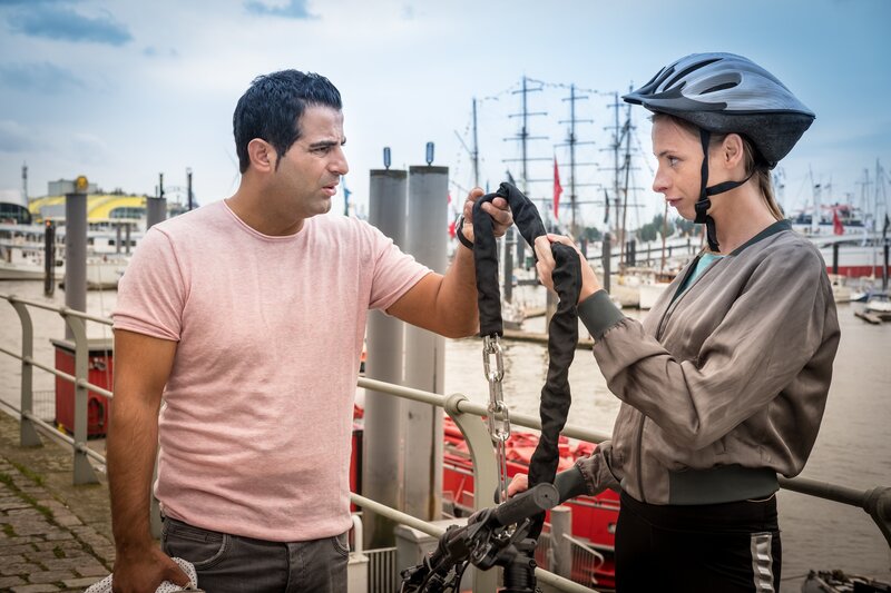 Tarik (Serhat Cokgezen, l.) neckt seine neue Kollegin Kim (Carolyn Genzkow, r.), die wegen entzogener Fahrerlaubnis mit dem Fahrrad zum Dienst kommen muss. – Bild: ZDF/​Boris Laewen