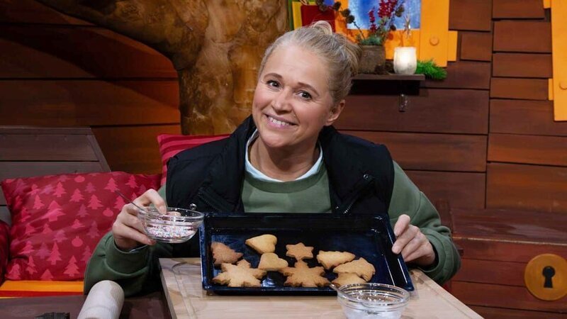 Singa hat Kekse gebacken und möchte sie verzieren. Nachdem sie ins Fernrohr geschaut hat, sind diese schon voller bunter Streusel. Da können nur die Wichtel dahinterstecken! – Bild: KiKA