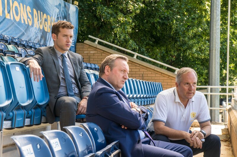 DCI John Barnaby (Neil Dudgeon, M.) und sein Assistent DS Jamie Winter (Nick Hendrix, l.) unterhalten sich mit Physiotherapeut Neville Gallagher (Michael Maloney) über den in einer Kältekammer erfrorenen Präsidenten der „Causton Lions“. – Bild: Mark Bourdillon /​ ZDF und Mark Bourdillon