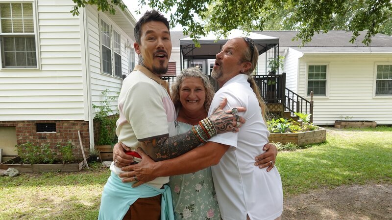 FROM LEFT TO RIGHT: HOST DAVID BROMSTAD POSE FOR A PICTURE WITH  LOTTERY WINNERS DEBORAH AND JOHN TEAGUE OUTSIDE OF HOUSE 3, BOTTLEBRUSH BAY – Bild: HGTV US