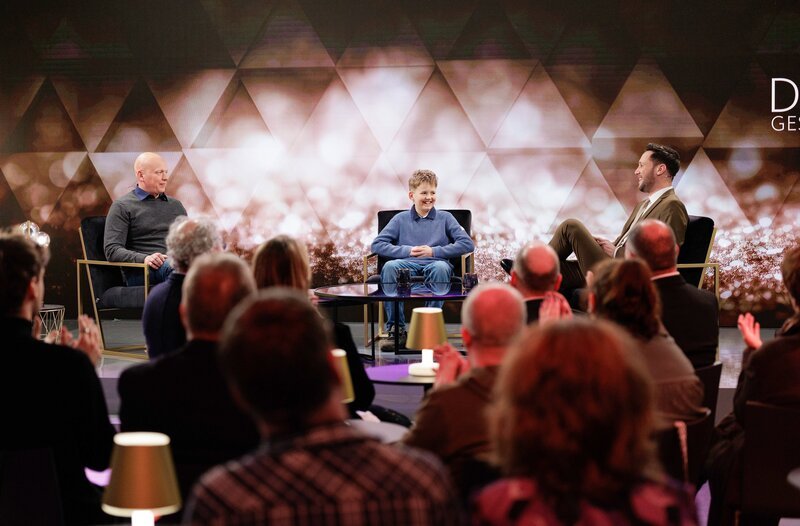 Kandidat Max Naber (Mitte) mit seinem Vater David Passon (l) und Sven Kroll (r) im Gespräch über „Der geschenkte Tag im Phantasialand“ – Bild: WDR/​Tilman Schenk