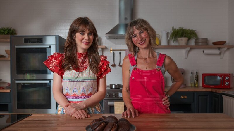 Zooey Deschanel and Jessie Sheehan with the Double Chocolate Malted Whoopie Pies, as seen on What Am I Eating? With Zooey Deschanel, Season 1. (posing) – Bild: Discovery, Inc. /​ Federico Imperiale