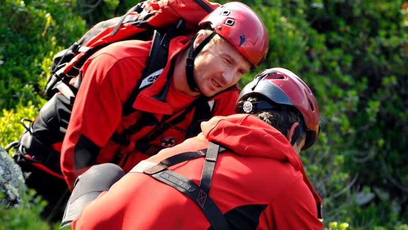 Der Bergdoktor Martin Gruber (Hans Sigl, r.) und sein Bruder Hans (Heiko Ruprecht, l.) leiten die Erstversorgung für die kleine Christina Lohmann (Stefanie Robotka) ein, die bei einem Schulausflug das Bewusstsein verloren hat und gestürzt ist. – Bild: ZDF und Thomas R. Schumann