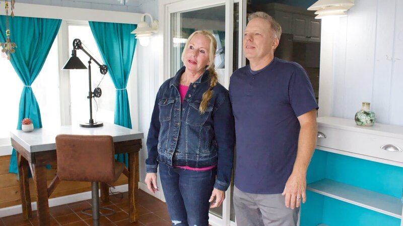 Bargain hunters Betteanne (L) and Ed (R) soak in the vacay vibes of Bay Breeze’s bright blue living room, as seen on HGTV’s original series, Beachfront Bargain Hunt. – Bild: Discovery, Inc. All Rights Reserved