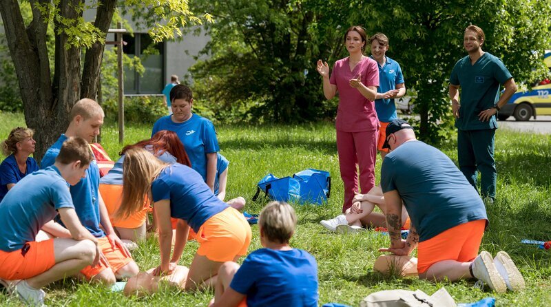 Viktoria Stadler (Isabella Krieger, h.3.v.r.) leitet den Erste-Hilfe-Kurs für die Mitarbeiter des örtlichen Freibads (Kompars:inen). Der Bademeister Dirk Dern (Felix Jordan, h.2.v.r.) und Mikko Rantala (Luan Gummich, r.) stehen Viktoria bei. – Bild: ARD/​Jens-Ulrich Koch