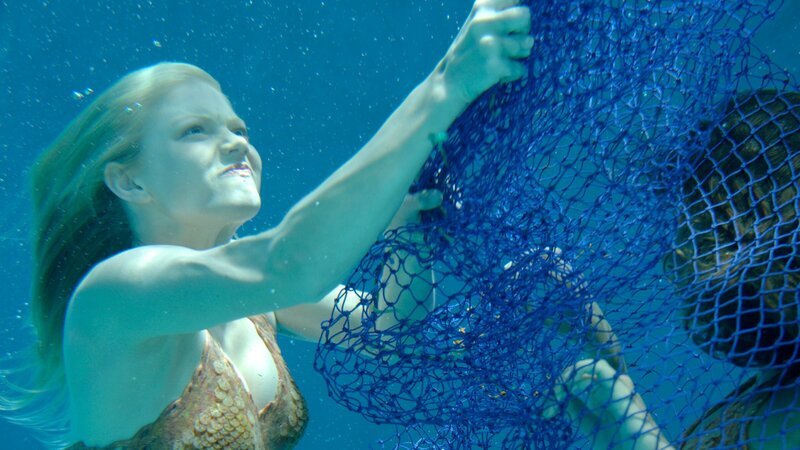 Cleo (Phoebe Tonkin, r.) hat sich bei ihrer Suche nach dem illegalen Schildkrötenfischer in einem Fischernetz verfangen und wird von Rikki (Cariba Heine, l.) befreit. – Bild: ZDF und Jasin Boland