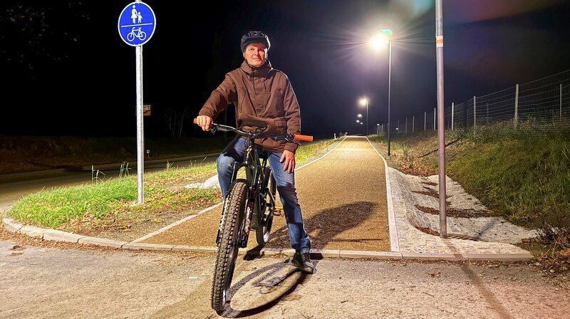 Jößnitzs Ortsvorsteher Christian Kellner ist Fan des neuen „HighTech-Öko-Radweges des Ortes. Das Besondere: Die Lampen leuchten nur da hell, wo Fahrradfahrer und Fußgänger den Weg nutzen. – Bild: MDR/​Steffi Peltzer-Büssow