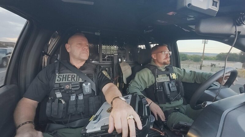 Polizeiauto in Landschaft (generisch) /​ police car in landscape (generic). – Bild: Warner Bros. Discovery, Inc. or its subsidiaries and affiliates. All rights reserved.