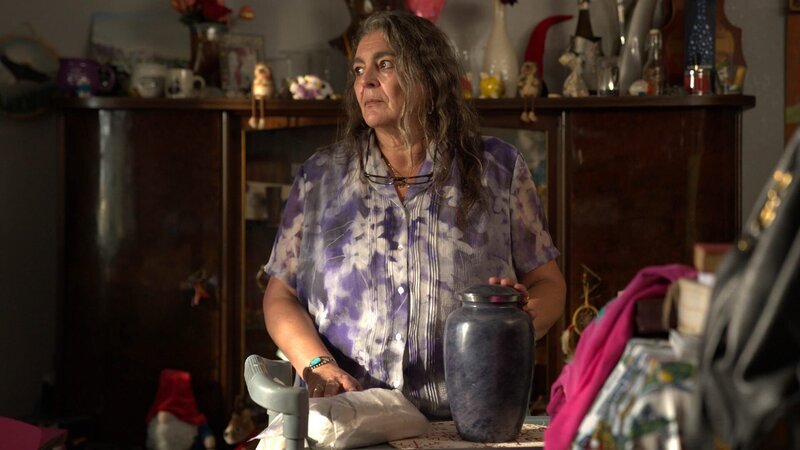 Angelika Stedman poses with urn – Bild: Warner Bros. Discovery, Inc. or its subsidiaries and affiliates