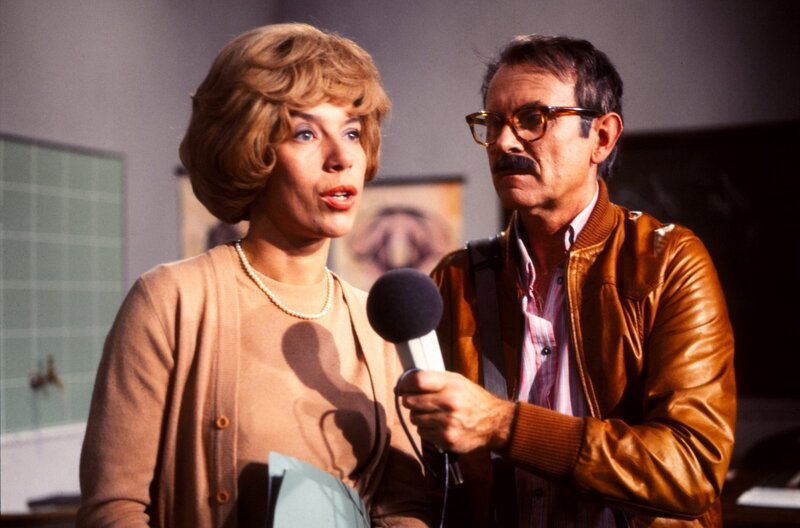 Frau Hoppenstedt (Evelyn Hamann) sucht ihr Glück nicht allein in ihren Hausfrauen- und Mutterpflichten, nein, sie baut sich nebenher eine berufliche Laufbahn auf, die so einmalig ist, dass sich sogar das Fernsehen dafür interessiert (rechts Loriot). – Bild: Radio Bremen/​Do Leibgirries