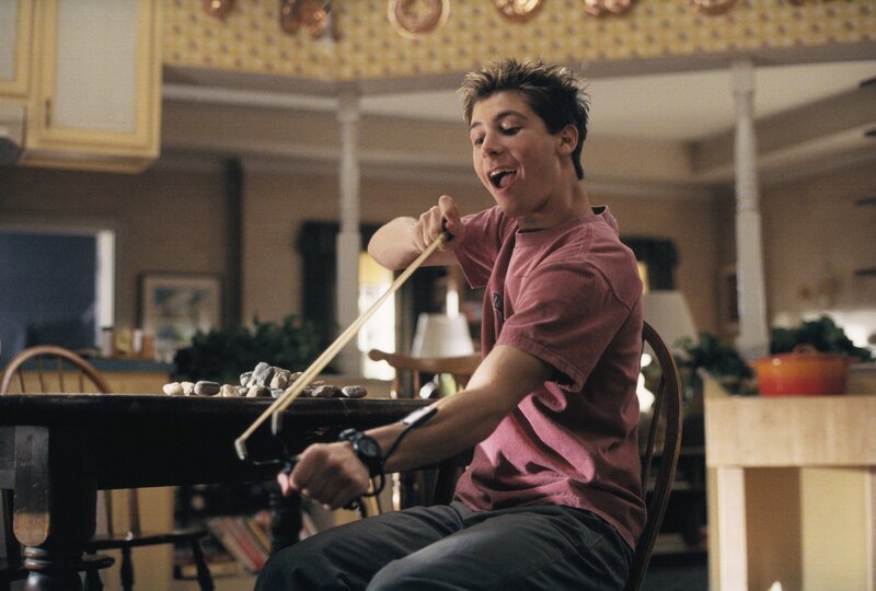 Reese (Justin Berfield) schießt mit einem selbstgebastelten Geschoss Steine auf die Füße seines kleinen Bruders. – Bild: ViacomCBS