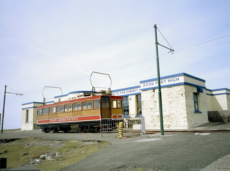 Elektrische Eisenbahn (Manx Electric Railway) entstanden durch den Umstand, dass die Steigungen und das Gefälle im Süden der Insel für die Dampflokomotiven zu steil waren. Sie sind die ältesten noch fahrenden Straßenbahnwagen der Welt (1893). Das Straßenbahndepot in der Inselhauptstadt Douglas schmückt sich mit einem riesigen Schriftzug, welcher dem in Hollywood Konkurrenz macht. – Bild: SWR/​Gratz