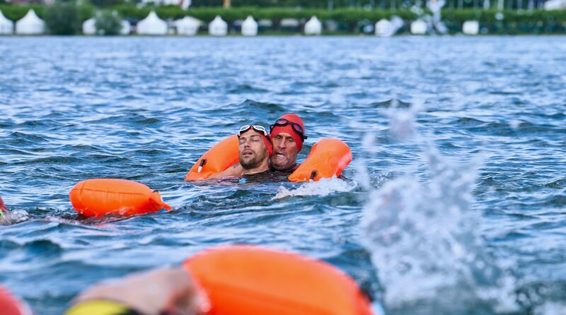 Paul Schott (Tim Wilde, r.) bringt Max Behringer (Jan Ruff, l.), der beim Freiwasser-Schwimmen kollabierte, zum Rettungsboot. – Bild: ARD/​Nicolas Gradicsky