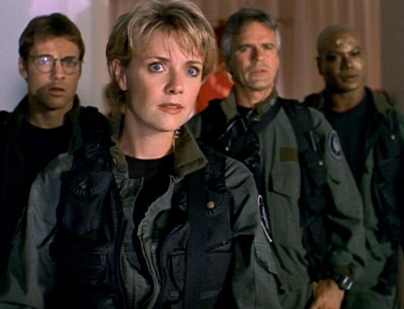 Jackson (Michael Shanks, li.), Carter (Amanda Tapping), O’Neill (Richard Dean Anderson) und Teal’c (Christopher Judge, re.) folgen Narim auf seinen Planeten. Sie sollen an einer ‚Triade‘ teilnehmen … – Bild: RTL II