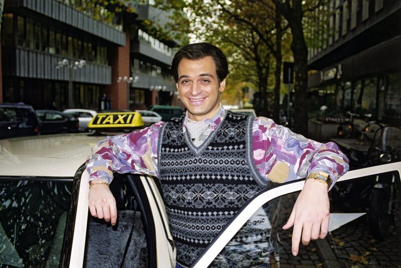 Der sympathische Inder Ranjid (Kaya Yanar) mit dem Dauerlächeln versucht es diesmal als Taxifahrer in Köln. – Bild: SAT.1 / Guido Engels Eigenproduktionsbild frei Der sympathische Inder Ranjid (Kaya Yanar) mit dem Dauerlächeln versucht es diesmal als Taxifahrer in Köln. – Bild: SAT.1 / Guido Engels Eigenproduktionsbild frei