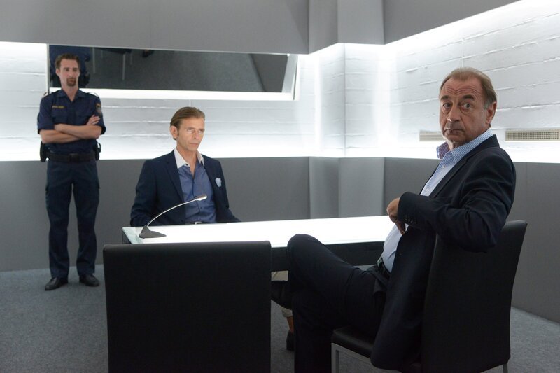 Gerald Praschak (Tonio Arango, M.) war der letzte Gast in Ritters Lokal, bevor dieser niedergeschlagen wurde und verschwunden ist. Nun wird er von Oberst Otto Dirnberger (Dietrich Siegl, r.) verhört. Dieser hat nämlich Zweifel an der Unschuld Praschaks. – Bild: Bavaria Media GmbH