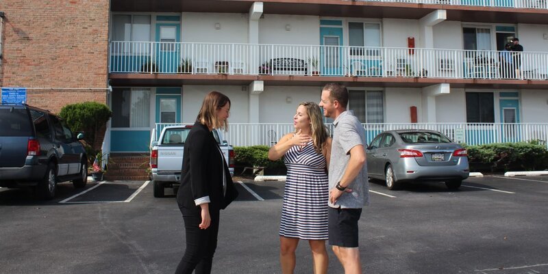 Real estate agent Madeleine Forrester (L) meets up with bargain hunters Rae Ritter (C) and Matt Ritter (R) before they check out Georgetown by the Sea as they shop for condos in Ocean City, Maryland, as seen on HGTV’s original series, Beachfront Bargain Hunt. – Bild: Discovery, Inc.