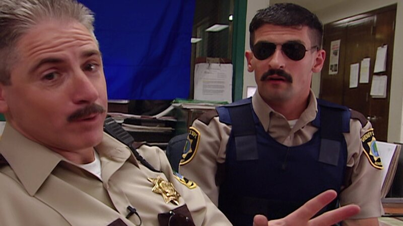 L-R: Deputy James Garcia (Carlos Alazraqui), Deputy Travis Junior (Robert Ben Garant) – Bild: ViacomCBS