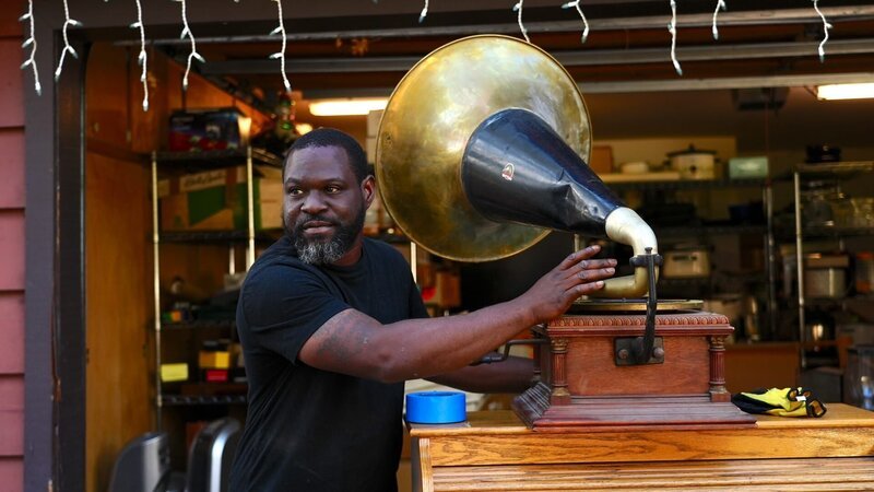Kayland Brock with phonograph that he found in the garage – Bild: Warner Bros. Discovery, Inc. or its subsidiaries and affiliates. All rights reserved.