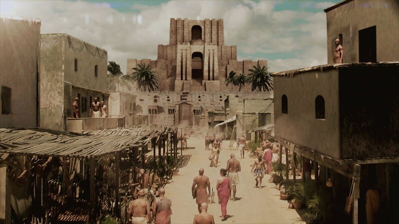 Straße mit Lehmhäusern und einem Zikkurat im Hintergrund, umgeben von Palmen und kleineren Gebäuden. – Bild: A+E Global Media THE HISTORY CHANNEL