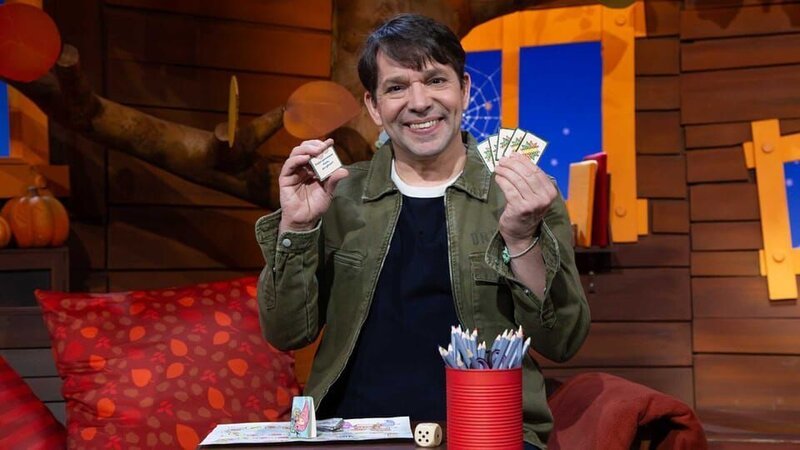 Es ist MACHMiT!-Woche im Baumhaus und Juri zeigt, was man mit den verschiedenen Spielkarten machen kann und deckt eine Aktionskarte auf. – Bild: KiKA