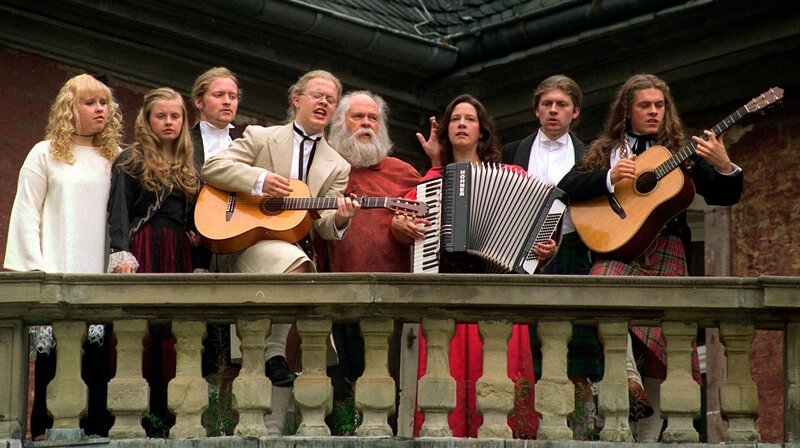 Das Jahr 1998 brachte einige Veränderungen: Ein Grüner Polizeipräsident musste gegen Atomkraft-Gegner vorgehen. Die Kelly Family zog um. Und Guildo Horn brachte Nussecken und den Schlager zum ESC. – Ein Ständchen für die Fotografen gibt am Montag die Kelly Family auf dem Balkon von Schloß Gymnich (Erftkreis). Die irische Musiker-Familie hatte rund 13 Millionen Mark für ihr neues Heim gezahlt, und ist knapp drei Monate nach der Ersteigerung von Schloß Gymnich in das frühere Gästehaus der Bundesregierung eingezogen. – Bild: WDR/​dpa