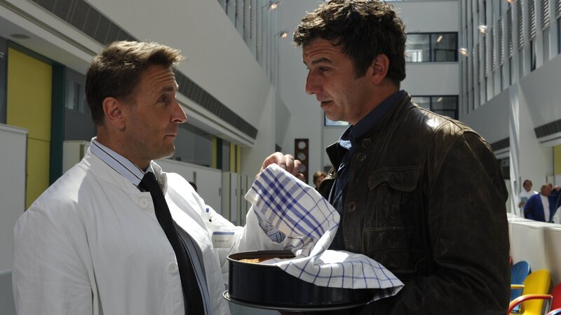 Martin Gruber (Hans Sigl, r.) will Susanne besuchen. Dr. Alexander Kahnweiler (Mark Keller, l.) glaubt, dass dahinter weit mehr steckt als bloße Freundschaft. – Bild: ZDF und Thomas R. Schumann