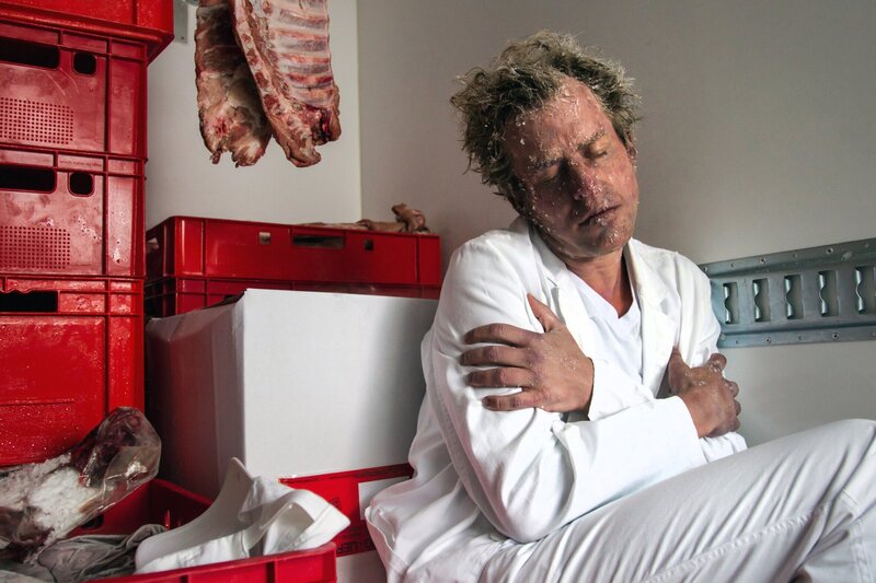 Im Kühlwagen der Großmetzgerei Semmling zwischen den Fleischwaren sitzt der Fahrer Stefan Schneider (Komparse) – unwürdig erfroren. – Bild: ARD/​ARD/​TMG/​Chris Hirschhäuser