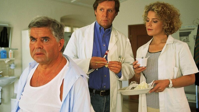 Modevertreter Bernd Sticker (Klaus Dahlen, l.) kommt wegen seines Übergewichts in Stefans (Sigmar Solbach) Praxis. Sprechstundenhilfe Marie Luise (Christiane Brammer) assistiert bei der Untersuchung. – Bild: MG RTL D /​ Elke Werner