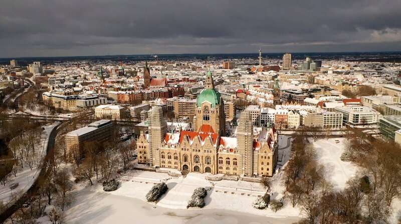 Schnee auch in der Landeshauptstadt, das Neue Rathaus im Sonnenschein, dahinter die City. – Bild: NDR/​AZ Media/​Holger Steller