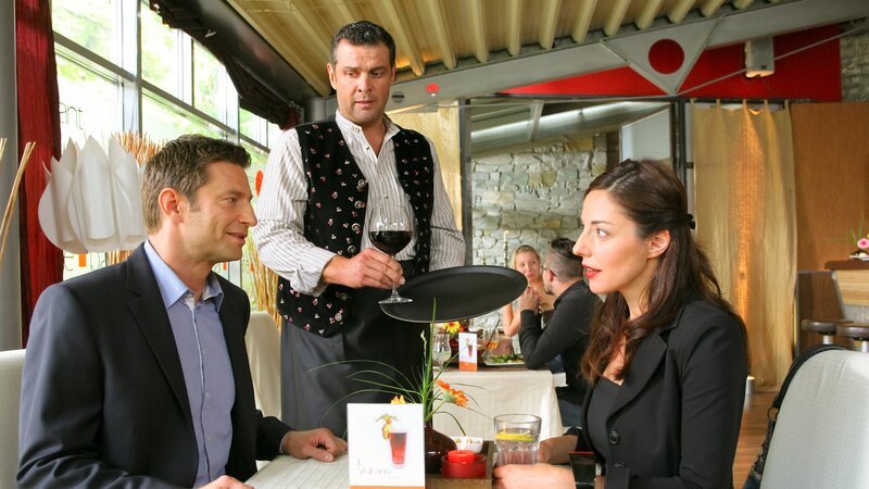 Obwohl Maßschneiderin Koch (Sabrina White, r.) unter Mordverdacht steht, verabredet sich Kommissar Hansen (Igor Jeftic, l.) zu einem Date bei Times Square-Wirt Jo (Christian K. Schaeffer, M.). – Bild: ZDF und Christian A. Rieger – klick