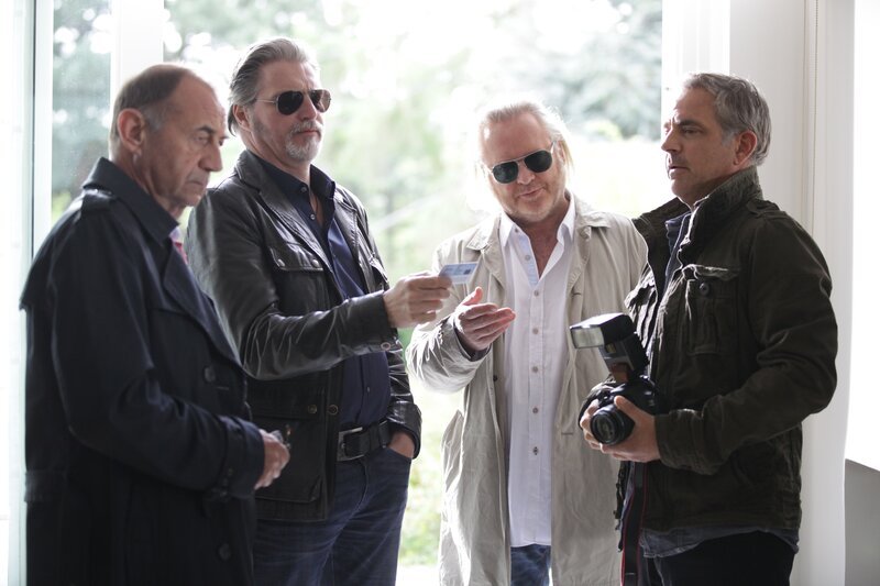 Journalist Philip Renard (Florian Fitz, r.) wird von Oberst Dirnberger (Dietrich Siegl, l.), Major Ribarski (Stefan Jürgens, M.) und Oberstleutnant Nowak (Gregor Seberg, M.) befragt, wieso er unerlaubter Weise Fotos am Tatort gemacht hat. – Bild: ZDF /​ Stefan Haring
