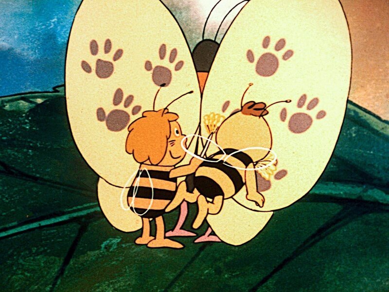 Der doppelte Flip hat dem Schmetterling übel mitgespielt. Maja und Willie versuchen, dem Schmetterling zu helfen. – Bild: ORF/​ZDF/​Apollo-Film