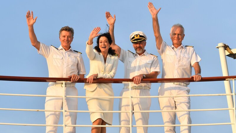 Unter der Führung des Ersten Offiziers Martin Grimm (Daniel Morgenroth, 2.v.r.) sticht das „Traumschiff“ in See. Gemeinsam mit Hanna Liebhold (Barbara Wussow, 2.v.l.), Dr. Sander (Nick Wilder, l.) und Oskar Schifferle (Harald Schmidt, r.) bereitet er den Gästen an Bord eine unvergessliche Reise nach Sambia. – Bild: ZDF und Dirk Bartling