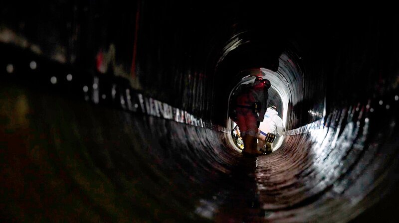 20 Meter unter der Elbe: Während unten die Sanierungsarbeiten stattfinden, fahren oben die dicken Pötte. – Bild: NDR