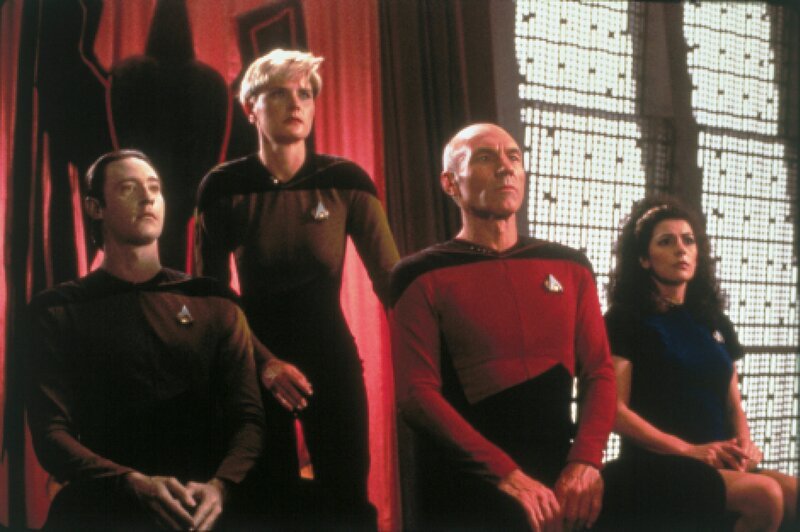 L-R: Data (Brent Spiner), Lieutenant Tasha Yar (Denise Crosby), Picard (Patrick Stewart) und Marina Sirtis (Counselor Deana Troi) – Bild: CBS /​ SYFY