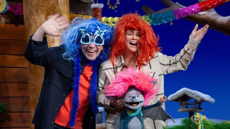 Fidi, Singa und Juri sind bereit für den letzten Abend des Jahres und singen und tanzen gemeinsam. Singa hat eine lustige Fotobox mit Verkleidungen dabei. – Bild: KiKA