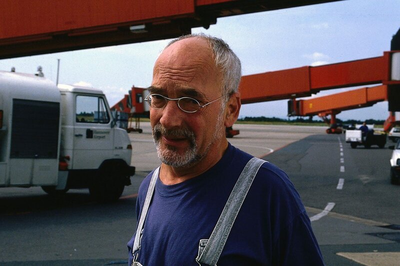 Überall auf dem Rollfeld sucht Peter (Peter Lustig) seinen Koffer. Vielleicht ist er ja vom Gepäckwagen gefallen und liegt irgendwo im Flughafengelände. – Bild: ZDF und Studio TV./​Studio TV