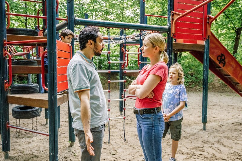 Firat (Eko Fresh) streitet mit Tristans Mutter (Levin Mahir), weil ihr Sohn (Levin Mahir, rechts) seinen Sohn Hugo (Balthazar Jakob, links) nicht auf die Schaukel lässt. – Bild: ORF/​BR/​ die film gmbh/​Hendrik Heiden